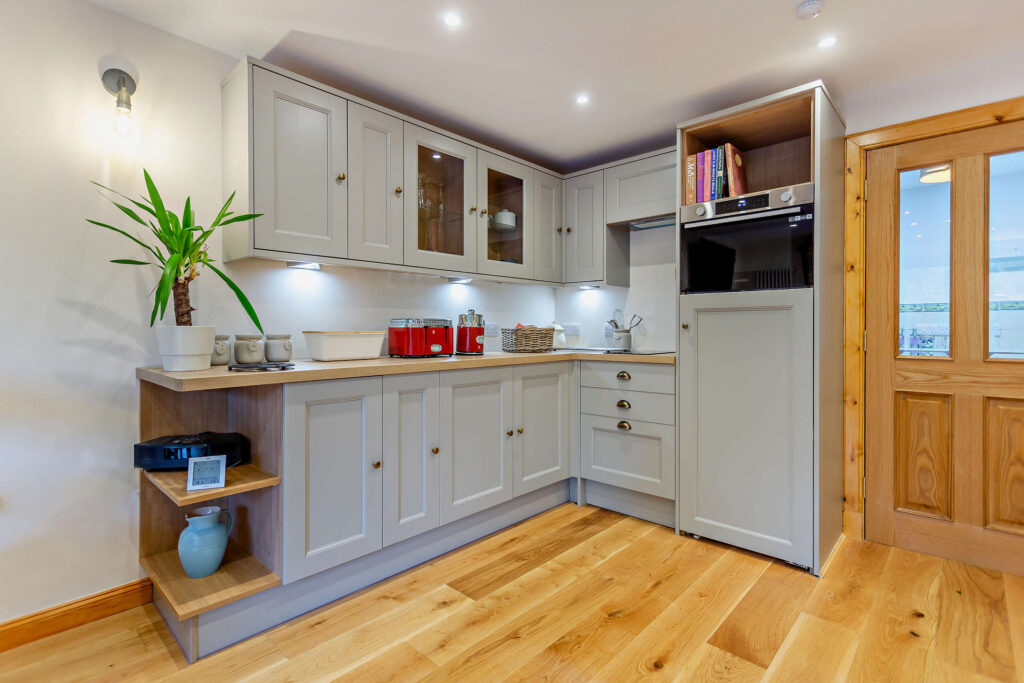 Modern kitchen at Highfield Lodge with fitted units, integrated oven and oak flooring.