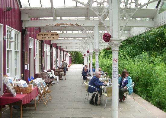 Covered platform at Strathpeffer railway station with outdoor seating beside the station café and museum.
