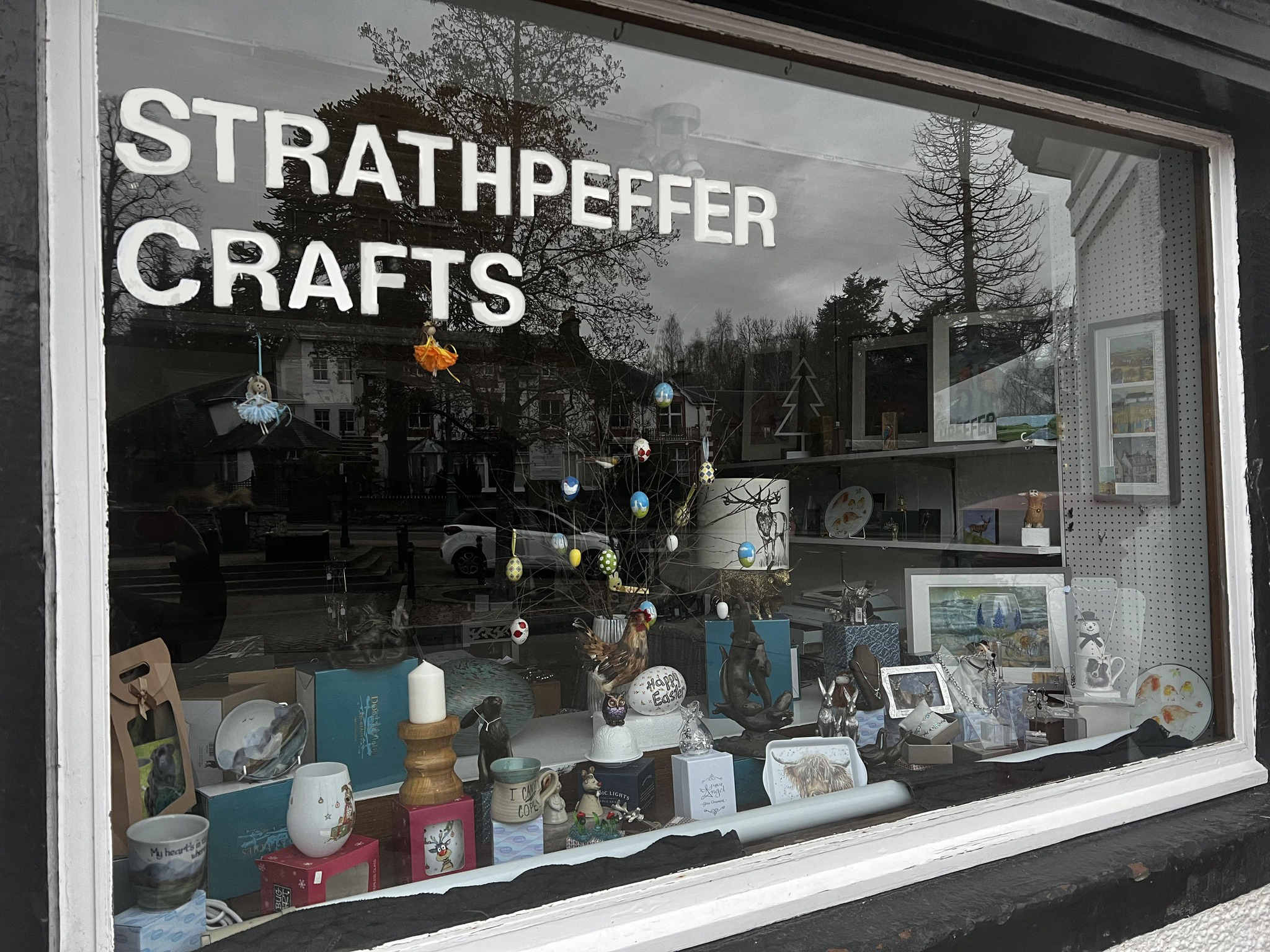 Window display at Strathpeffer Crafts in The Square, filled with locally made gifts, artwork and ceramics.