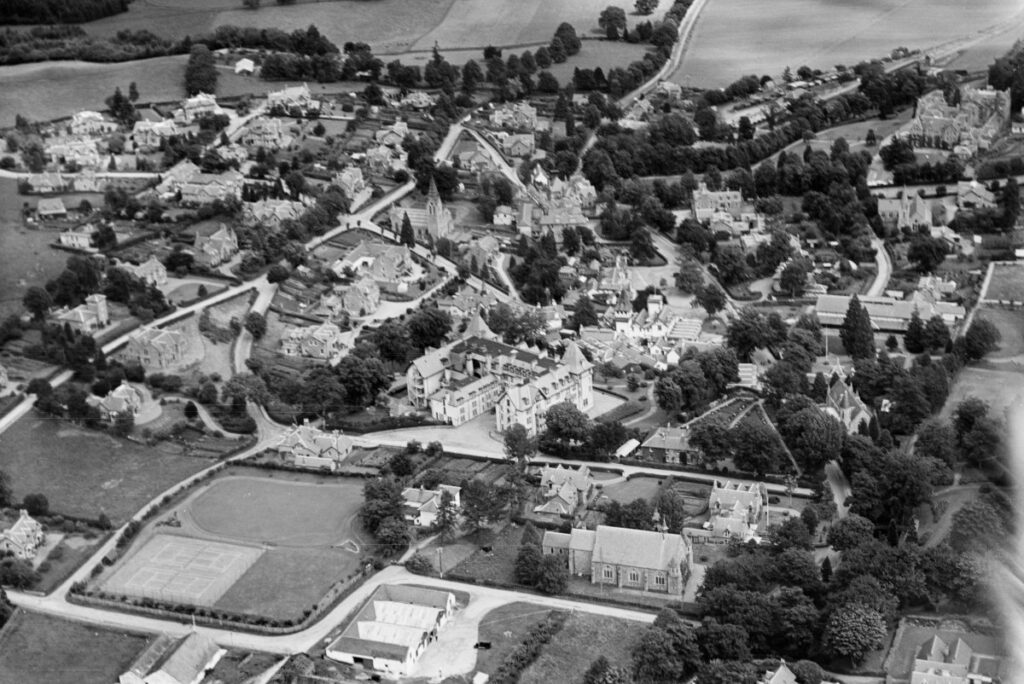 Black and white aerial photograph of Strathpeffer in the 1930s, with the Highland Hotel at the centre and Highfield House and the tennis courts visible in the lower left.