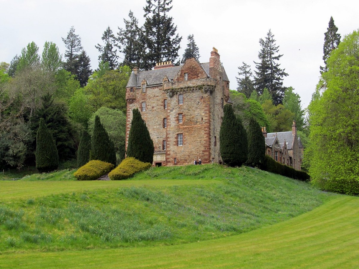 Castle Leod near Strathpeffer, seen from the lawn with its stone tower, turrets and wooded backdrop.